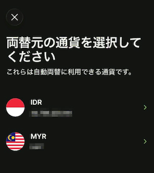 Wiseアプリの自動両替設定画面。「両替元の通貨を選択してください」と表示され、IDR（インドネシアルピア）とMYR（マレーシアリンギット）が選択肢として表示されている